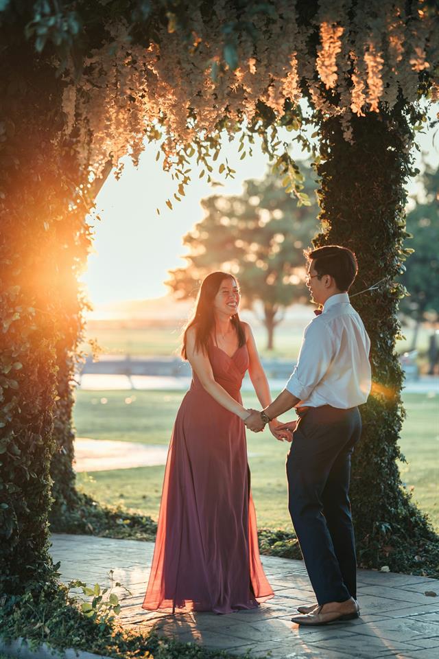 Novios bailando en un campo al atardecer