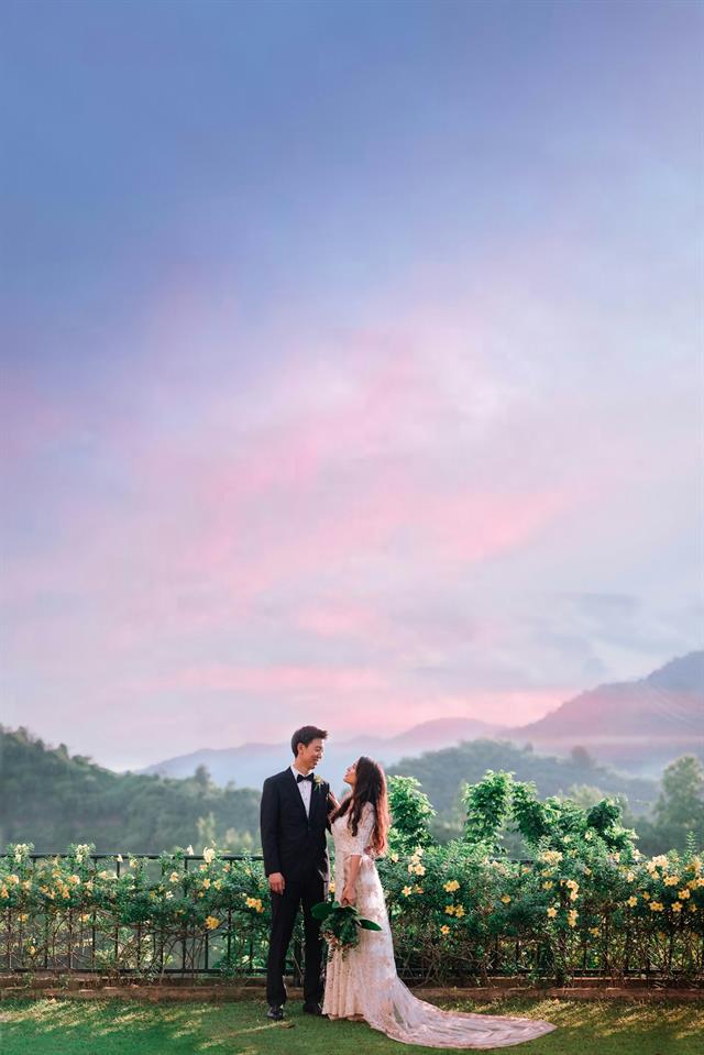 Novios en un viñedo con montañas al fondo