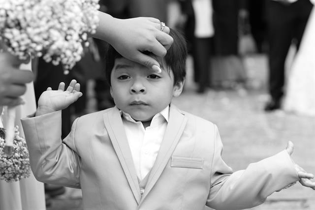 Niño de primera comunión con traje y brazos abiertos