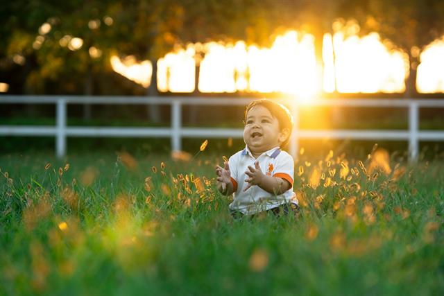 Niña jugando en el campo al atardecer