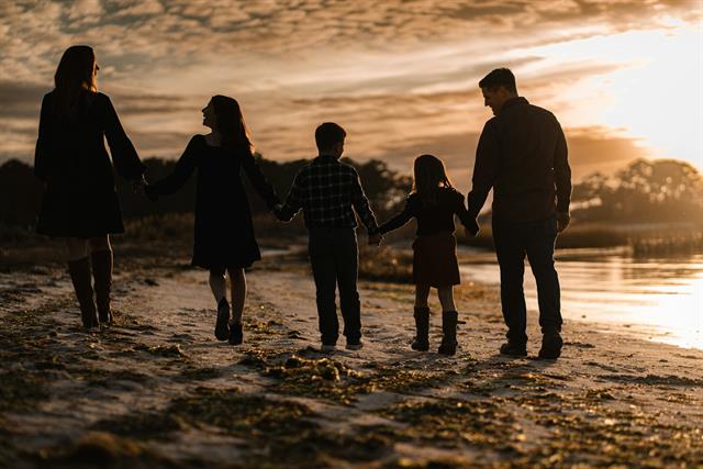 Silueta de una familia al atardecer junto al lago