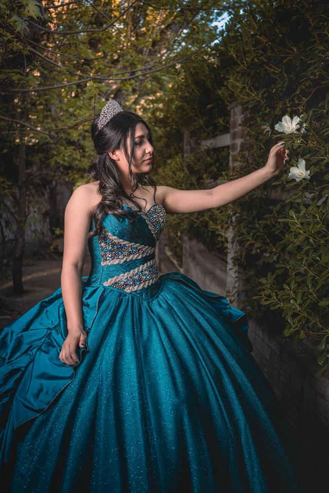 Quinceañera bailando con vestido azul