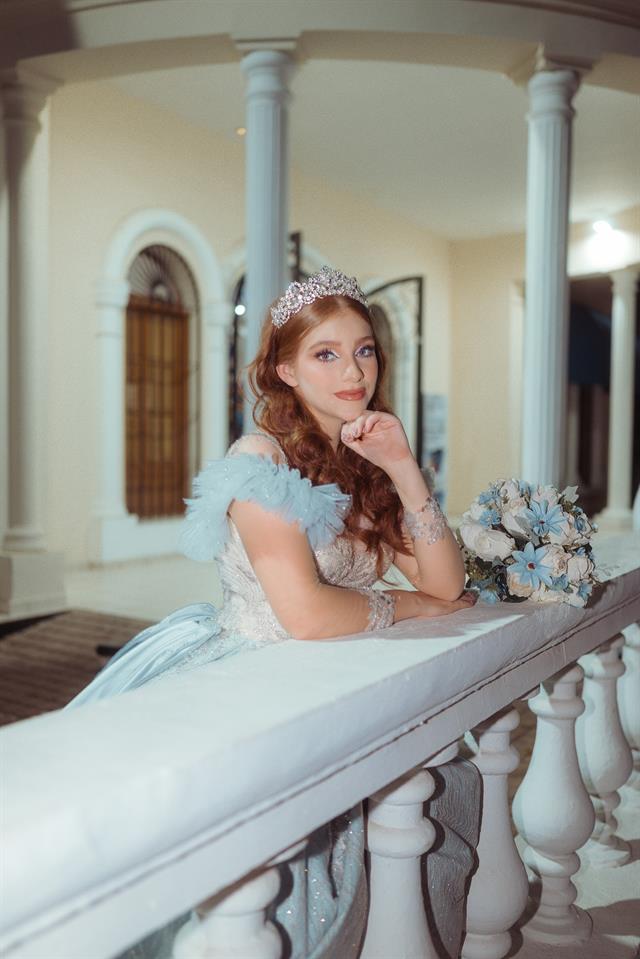 Quinceañera con vestido blanco en una escalinata